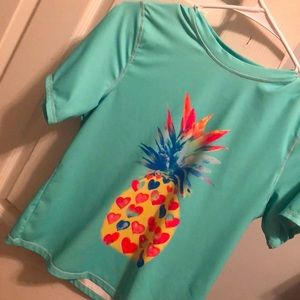 A  swim-shirt with a vibrant colorful pineapple